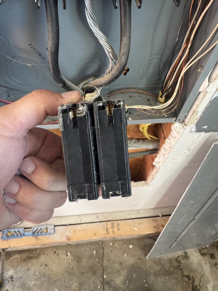 Electrician holding breakers pulled from a panel