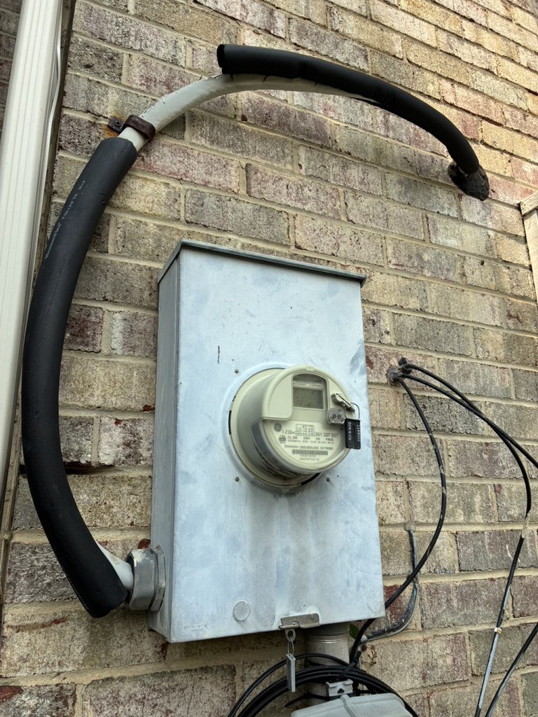 Electric meter and service cable on a brick home